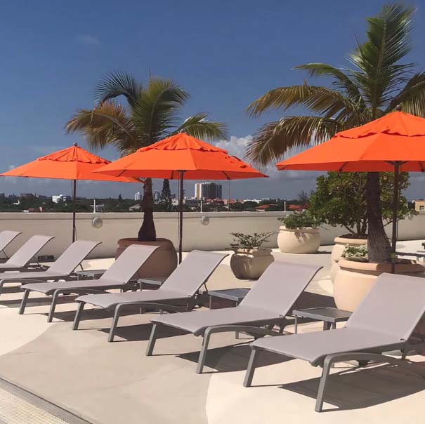5. Grosfillex- poolside sun loungers & orange parasols
